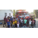 Group photo of kids with fireman hats in front of firetruck