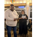  A woman reads a paper while a man accepts an award. 